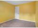 A bedroom with bright yellow walls, neutral carpet, and a white door at 502 S Harrison St, Alexandria, IN 46001