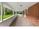Covered back porch with brick accents and a view of the lush backyard at 502 S Harrison St, Alexandria, IN 46001
