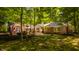 Backyard view of the house through the trees showing a patio with white furniture and outdoor dining at 535 W 93Rd St, Indianapolis, IN 46260