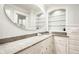 Elegant bathroom featuring a granite countertop, round mirror, and decorative glass shelving at 535 W 93Rd St, Indianapolis, IN 46260