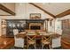 Elegant dining room featuring a rustic wooden table, brick fireplace, and exposed beams at 535 W 93Rd St, Indianapolis, IN 46260