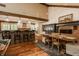 Open-concept dining area with brick bar seating, wood table, fireplace, and a view into the kitchen at 535 W 93Rd St, Indianapolis, IN 46260