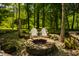 Relaxing backyard fire pit with Adirondack chairs nestled amongst trees, creating a cozy outdoor gathering space at 535 W 93Rd St, Indianapolis, IN 46260