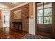 Elegant foyer with brick accent wall, dark wood floors, wood door, and stylish decor, creating a welcoming entrance at 535 W 93Rd St, Indianapolis, IN 46260