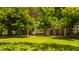 Spacious front lawn offering partial views of a brick house framed by mature trees and lush foliage at 535 W 93Rd St, Indianapolis, IN 46260