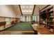 Entertaining game room with a pool table, bookshelf, and ample natural light at 535 W 93Rd St, Indianapolis, IN 46260