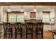 Charming kitchen featuring a brick backsplash, bar-style seating, white cabinets, and pendant lighting at 535 W 93Rd St, Indianapolis, IN 46260