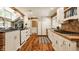 Spacious kitchen showcasing an island with brick accents, white cabinets, and stainless steel appliances at 535 W 93Rd St, Indianapolis, IN 46260