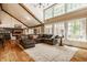 Bright living room with high ceilings, large windows, hardwood floors, and a comfortable leather sectional sofa at 535 W 93Rd St, Indianapolis, IN 46260