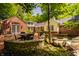 Outdoor patio with brick paving, surrounded by lush greenery and equipped with outdoor furniture at 535 W 93Rd St, Indianapolis, IN 46260