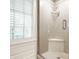 Bright shower featuring a glass door, built-in seat, and modern chrome fixtures at 535 W 93Rd St, Indianapolis, IN 46260