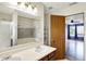 Bright bathroom with double sinks, large mirror, and tub/shower combination adjacent to a bedroom at 539 Deer Trail Dr, Indianapolis, IN 46217