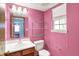 Cozy pink bathroom featuring a vanity, toilet, shelving, and a window for natural light at 539 Deer Trail Dr, Indianapolis, IN 46217