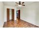 Bedroom with wood floors, ceiling fan and bi-fold closet doors, and access to other rooms at 539 Deer Trail Dr, Indianapolis, IN 46217