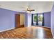 Bedroom with purple walls, ceiling fan, wood-look floors, and closet at 539 Deer Trail Dr, Indianapolis, IN 46217