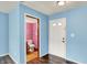 Bright entryway featuring hardwood floors, a white door, and a glimpse into a colorful pink bathroom at 539 Deer Trail Dr, Indianapolis, IN 46217