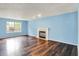 Bright living room featuring a fireplace, large window, hardwood floors, and light blue walls at 539 Deer Trail Dr, Indianapolis, IN 46217