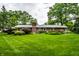 Wide shot of a lush green backyard with mature trees and manicured shrubbery at 5415 Kilmer Ln, Indianapolis, IN 46250