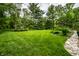 Lush green backyard lawn with manicured landscaping and a stone paver path to the right at 5415 Kilmer Ln, Indianapolis, IN 46250