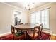Bright dining room with a large window, wooden table, and hardwood flooring with an open view to the kitchen at 5415 Kilmer Ln, Indianapolis, IN 46250