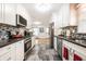 Renovated kitchen featuring modern appliances, white cabinets, granite countertops, and tiled floors at 5415 Kilmer Ln, Indianapolis, IN 46250