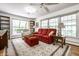Cozy living room featuring a bright red sofa, many windows, and comfortable seating at 5415 Kilmer Ln, Indianapolis, IN 46250