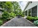 Long gravel patio with a black metal table and chairs surrounded by beautiful greenery at 5415 Kilmer Ln, Indianapolis, IN 46250