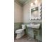Bathroom features green paneled walls, modern sink, golden fixtures and decorative mirror at 5682 Broadway St, Indianapolis, IN 46220