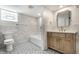 Basement bathroom featuring patterned tile flooring and a bathtub/shower combination at 5682 Broadway St, Indianapolis, IN 46220