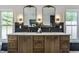 Elegant bathroom with dual sinks, stone countertops, stylish light fixtures, and black subway tile backsplash at 5682 Broadway St, Indianapolis, IN 46220
