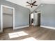 Spacious bedroom with wood floors, ceiling fan, ensuite bathroom, and walk-in closet at 5682 Broadway St, Indianapolis, IN 46220