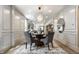 Formal dining room with modern chandelier, wood floors, and paneled walls at 5682 Broadway St, Indianapolis, IN 46220