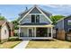 Attractive two-story home with welcoming front porch and new lawn at 5682 Broadway St, Indianapolis, IN 46220