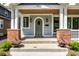 Charming front porch with wood ceiling, brick pillars and an arched front door at 5682 Broadway St, Indianapolis, IN 46220