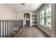Open and airy hallway showcases hardwood flooring, and accent shelving with light filled window at 5682 Broadway St, Indianapolis, IN 46220