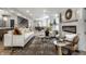 Bright living room featuring modern furniture, decorative fireplace, and an open floor plan to the dining area at 5682 Broadway St, Indianapolis, IN 46220