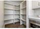 Walk-in pantry featuring white shelving, stainless steel microwave and hardwood flooring at 5682 Broadway St, Indianapolis, IN 46220