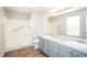 Bathroom featuring double sinks, granite counters, shower stall and wood-look flooring at 6121 Jester Ct, Indianapolis, IN 46254