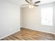 A light-filled bedroom with a ceiling fan, wood-look floors and a bright white window at 6121 Jester Ct, Indianapolis, IN 46254