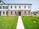 Inviting two-story townhouse featuring a brick facade, bright white siding, and a well-manicured lawn at 6192 Cascades Dr, Whitestown, IN 46075