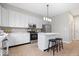 Modern kitchen with stainless steel appliances, white cabinets, and center island with seating at 6528 Abby Ln, Zionsville, IN 46077