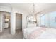Charming bedroom featuring a crystal chandelier, striped accent wall, and pink decorative accents at 6868 Jacone Dr, Brownsburg, IN 46112