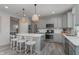 Modern kitchen featuring stainless steel appliances, grey cabinets, and a large center island with seating at 6868 Jacone Dr, Brownsburg, IN 46112