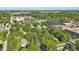 Wide aerial view of the property, surrounding mature trees, and neighboring community at 710 N Spring St, Greenfield, IN 46140