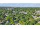 High aerial view of the property, surrounding mature trees, and neighboring community at 710 N Spring St, Greenfield, IN 46140