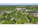 Wide aerial view of the property, surrounding mature trees, and neighboring community at 710 N Spring St, Greenfield, IN 46140
