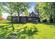 Lush backyard featuring a mature tree and a stone pathway to a home with a cozy back deck at 710 N Spring St, Greenfield, IN 46140