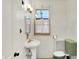 Retro bathroom with vintage green fixtures, white tile walls, and a pedestal sink at 710 N Spring St, Greenfield, IN 46140