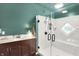 Bathroom featuring green walls, a shower with a clear glass door, vanity and lighting at 710 N Spring St, Greenfield, IN 46140