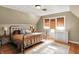 Cozy bedroom with an iron bed frame, wood floors, neutral walls, and a window with a woven shade at 710 N Spring St, Greenfield, IN 46140